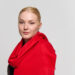 A model styled in a charcoal and red cashmere scarf, representing the brand's global appeal.