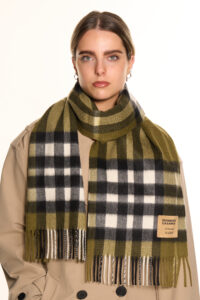 A high-fashion editorial shot of a red tartan cashmere scarf.