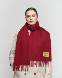 A folded light brown cashmere scarf in a luxury signature box.